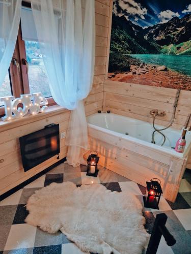 a bathroom with a bath tub and a large window at Góralska Chata in Czarna Góra