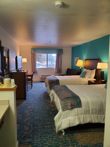 a hotel room with two beds and a television at Omak Inn in Omak