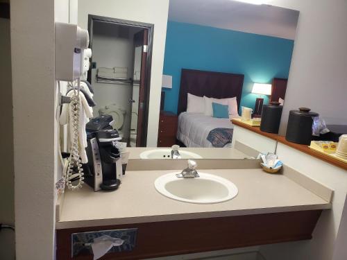 a hotel room with a sink and a bed at Omak Inn in Omak
