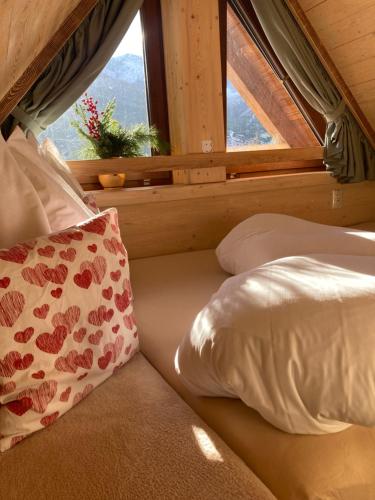 Cama con almohada y ventana en una habitación en VILA Tatry Ždiar - Domček pre dvoch, en Ždiar