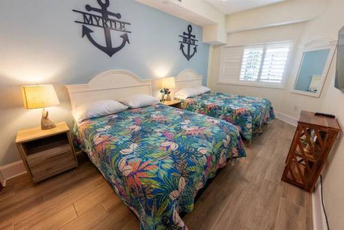 a bedroom with two beds and a table with lamps at Your Beachfront Resort Oasis in Myrtle Beach