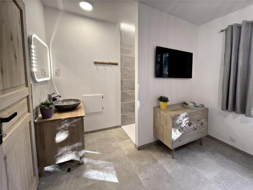 baño con lavabo y TV en la pared en Villa Les Agrions avec piscine, en Le Thoronet
