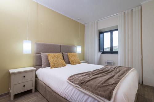 a bedroom with a large bed and a window at Casa da Professora By ALzira in Seia
