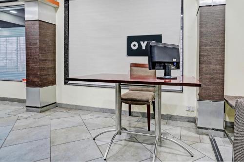 a desk with a computer sitting on top of it at Super OYO Flagship Hotel Golden Nest in Saravli