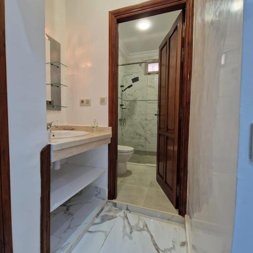 Bel appartement de 2 chambres في مراكش: حمام مع حوض ودش