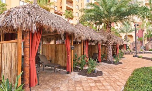 a row of shelters with thatched roofs and palm trees at Bonnet Creek Resort 1 Bedroom 1 BA Deluxe Villa in Orlando