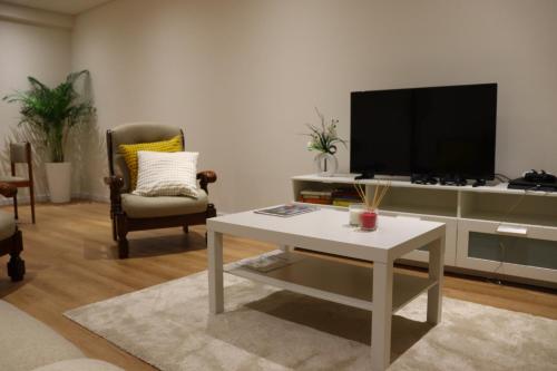 a living room with a tv and a white coffee table at Arouca Guest House 2 in Arouca