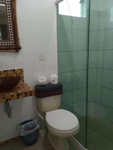 a bathroom with a toilet and a glass shower at Pousada Frida in Penha