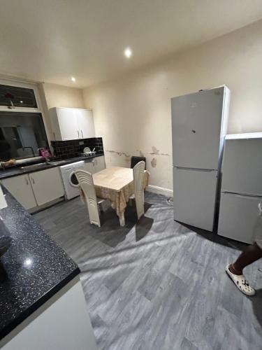 a kitchen with a table and a refrigerator at 40 vicarage street in Failsworth