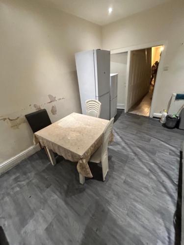 a room with a table and a refrigerator at 40 vicarage street in Failsworth