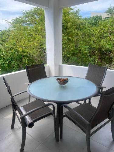 a blue table and chairs on a balcony with a window at Buda Blanca 5 min caminando a la playa in Cuatunalco