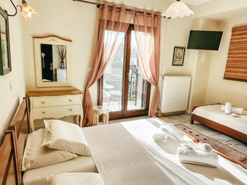a bedroom with a large bed and a window at Filimon GuestHouse Villa in Xanthi