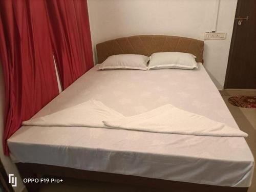 a bed with white sheets and pillows on it at Dona Residency in Nedumbassery