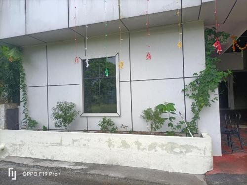 un edificio con una ventana y plantas en él en Dona Residency en Nedumbassery