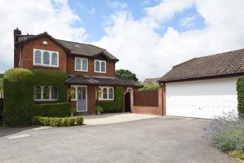 a brick house with a white garage at Beautiful Meon Valley Family Home in Shedfield