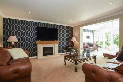 a living room with a couch and a fireplace at Beautiful Meon Valley Family Home in Shedfield