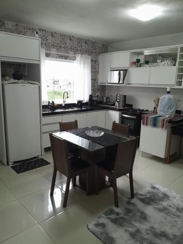 a kitchen with a table and chairs and a refrigerator at Hostel bons sonhos Um Quarto uma Cama de Casal in Penha