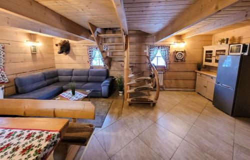 sala de estar con sofá azul y nevera en Pokoje Gosinne U Ani i Andrzeja, en Małe Ciche