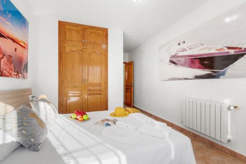 a bedroom with a white bed with a picture of a boat on the wall at Villa Navacerrada - PlusHolidays in Teulada