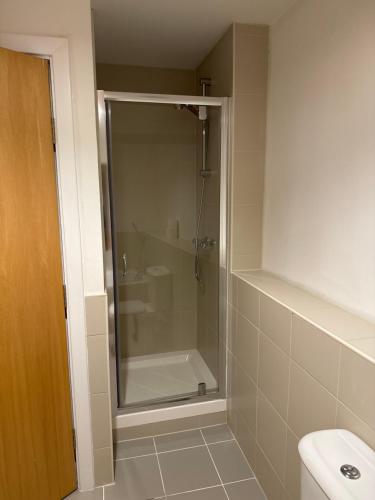 a glass shower in a bathroom with a sink at 23 Lochburn Gardens - Carz in Maryhill