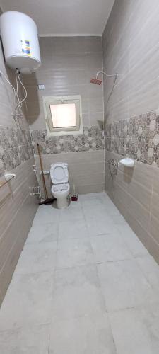a bathroom with a toilet and a window at Ahmed House 1 in Safaga 