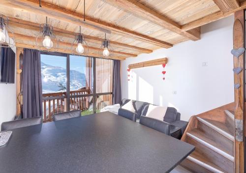 une salle à manger avec une table et un balcon dans l'établissement Val Thorens So Cocooon Silveralp 329, à Val Thorens