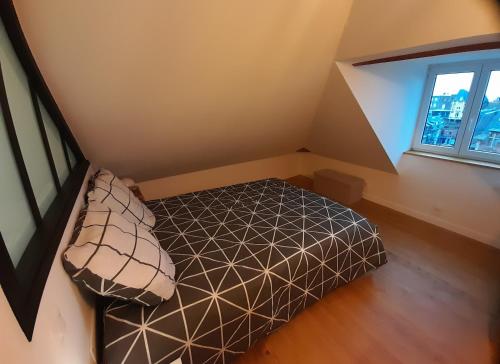 an attic room with a bed and a window at "Le JUGUILI" 46m2 en front de Mer - 4 personnes - animaux OK - Entièrement rénové - Haut de gamme - wifi in Mers-les-Bains
