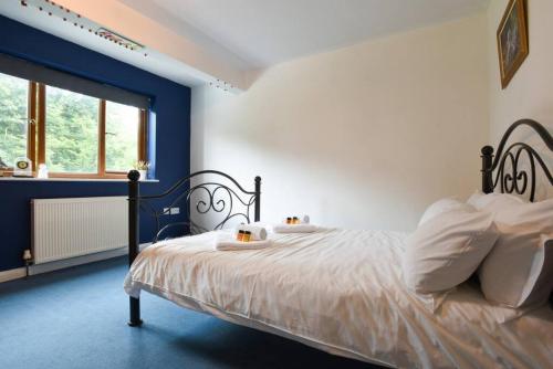 a blue and white bedroom with a bed with white pillows at Large family home pool table in Waterlooville