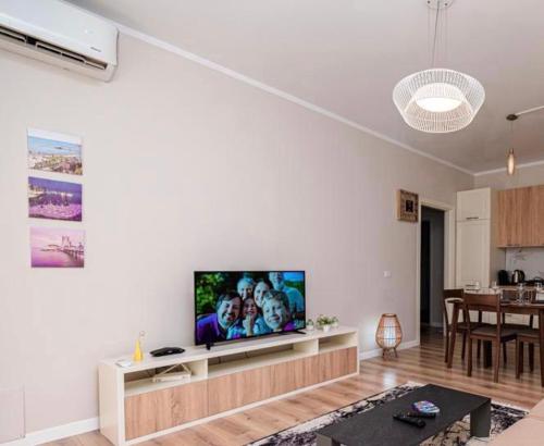un soggiorno con TV a schermo piatto su una parete bianca di Loris Apartaments 205 a Durrës