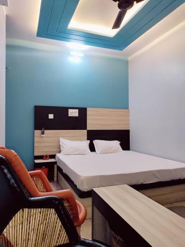 Zimmer mit 2 Betten, einem Sofa und einem Stuhl in der Unterkunft Hotel silver spoon and restaurant bhadra in Bhādra