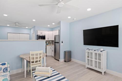 eine Küche mit einem Tisch und einem TV an der Wand in der Unterkunft Captain Ed's - Charming Studio at PalmView of Sanibel with Bikes in Sanibel