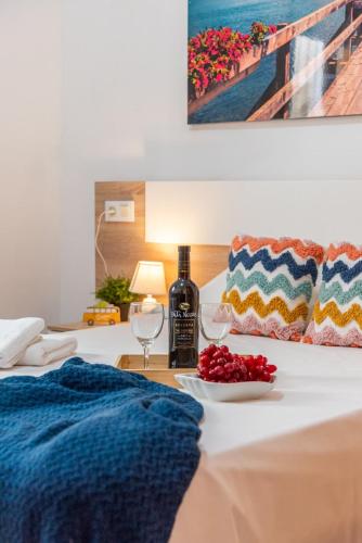a bed with a bottle of wine and a plate of fruit at Villa Navacerrada - PlusHolidays in Teulada
