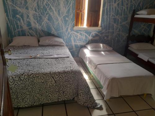 2 camas en una habitación con paredes azules en Pousada Vila Do Porto Ar Condicionado e Cafe Da Manha en Porto Seguro