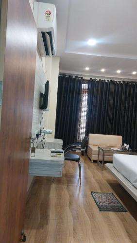 une chambre avec un lit et un salon avec un canapé dans l'établissement Hotel Swarat Inn By BookingCare, à Amarpātan