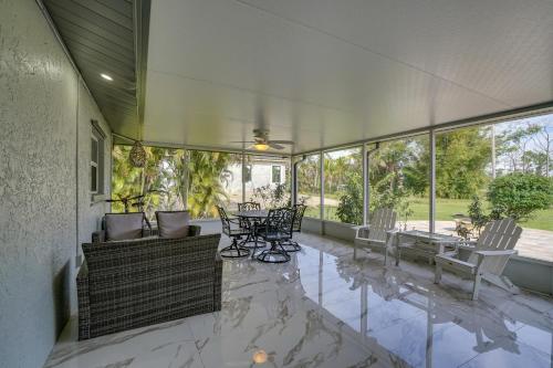 an empty porch with chairs and tables and windows at Game Room and Screened Lanai Pine Island Getaway! in Matlacha