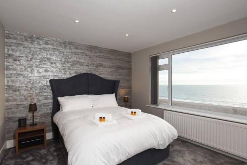 een slaapkamer met een groot bed en een groot raam bij Amazing view High end beachfront 3BR 5beds 7 guest in South Hayling
