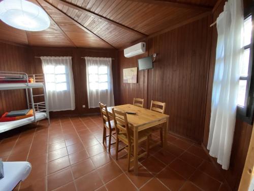 jadalnia ze stołem i krzesłami oraz łóżkiem piętrowym w obiekcie YMCA Camp Alambre w mieście Azeitão