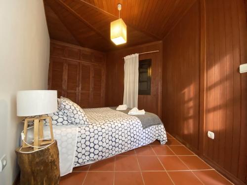 a bedroom with a bed and a lamp in a room at YMCA Camp Alambre in Azeitao