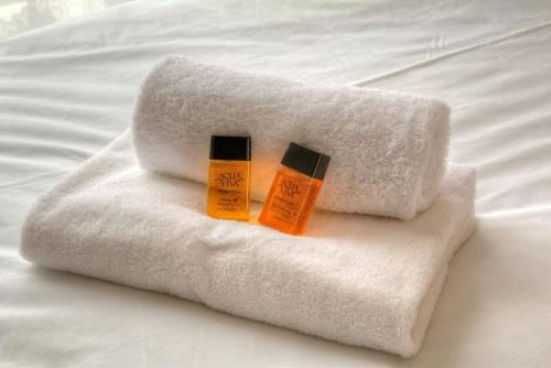 two bottles of sunscreen sitting on top of a white towel at Modern 2BR w sea views beach access in South Hayling