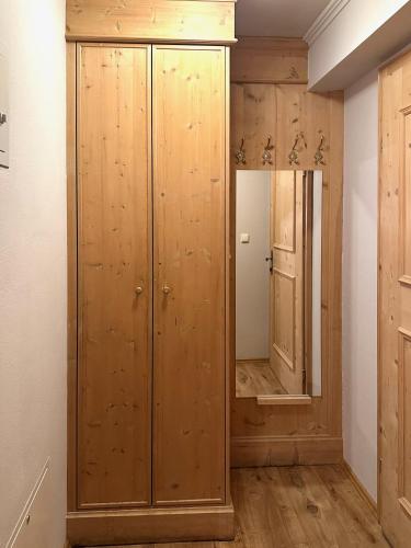 a dressing room with wooden cabinets and a mirror at Apartments Max & Moritz in Kirchberg in Tirol