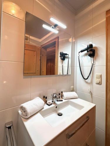 a bathroom with a sink and a mirror at Apartments Max & Moritz in Kirchberg in Tirol