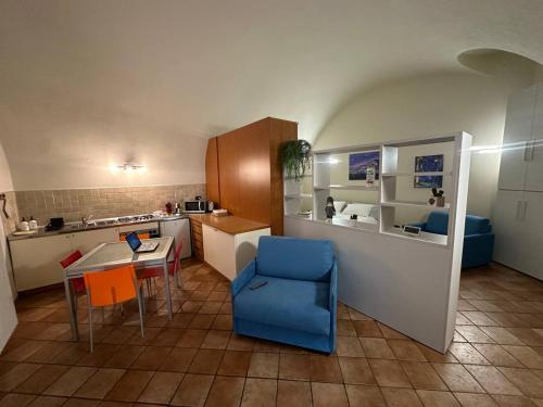 a small kitchen with a table and a blue chair at Casa Beccarie in Lovere