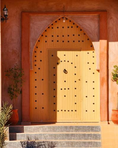 a wooden door on the side of a building at Merzouga Lodge in Merzouga