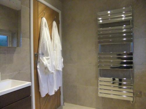 a bathroom with white towels hanging on a wall at The Count House in Saint Hilary