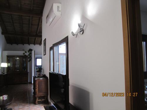 a living room with a white wall and a tv at Casa do Castelo in Redondo