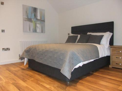 a bedroom with a large bed and a wooden floor at The Count House in Saint Hilary