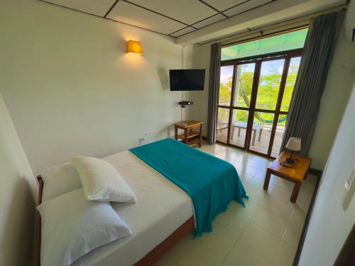 um quarto com uma cama com um cobertor azul em South West Bay Cabañas em Providencia