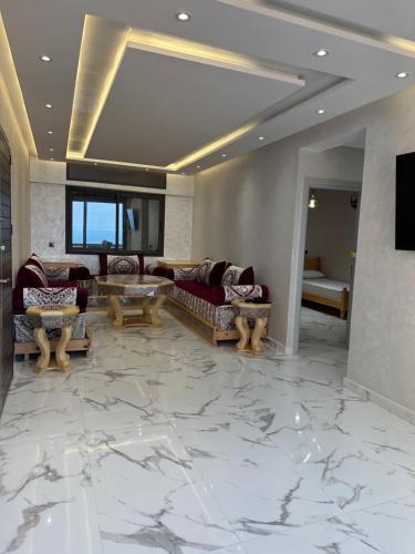 ein Wohnzimmer mit Marmorböden und Sofas in der Unterkunft Ferienwohnung mit Meerblick in Al Hoceïma