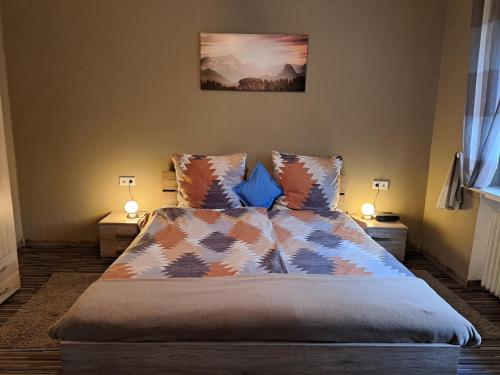 ein Schlafzimmer mit einem Bett mit Kissen und zwei Lampen in der Unterkunft Ochmanns Ferienwohnung in Meschede