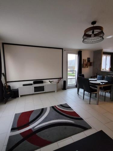 a living room with a large projection screen on the wall at Duplex proche Disney avec écran cinéma in Chessy